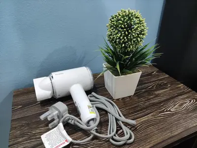 a hair dryer on a table next to a plant at Cozyhaus Stay Sanctuary-Netflix-Pool- 1 Parking in Taiping