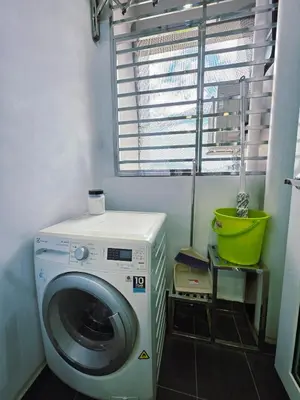 a washing machine in a laundry room with a window at StayLuxe SGS 2BR Suite in George Town