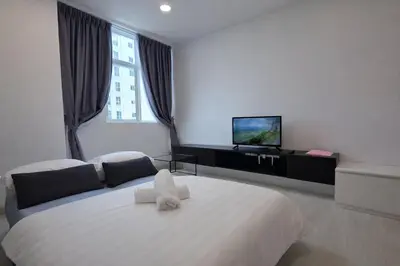 a bedroom with a large white bed with a flat screen tv at StayLuxe SGS 2BR Suite in George Town