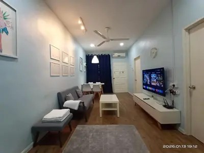 a living room with a couch and a tv at Adno Homestay Batu Kawan 2QB1SB in Simpang Ampat