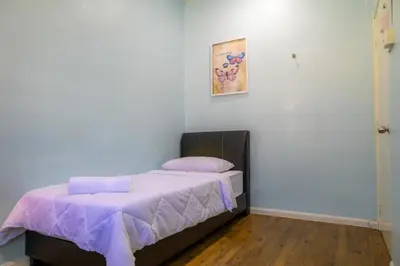 a bedroom with a bed with a purple bedspread at Adno Homestay Batu Kawan 2QB1SB in Simpang Ampat