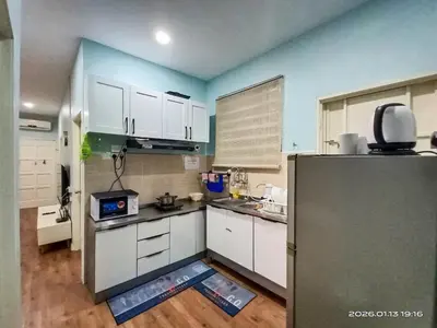 a kitchen with white cabinets and a refrigerator at Adno Homestay Batu Kawan 2QB1SB in Simpang Ampat