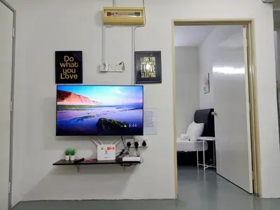 a living room with a tv on a wall at Adno Homestay Batu Kawan 5SB in Simpang Ampat