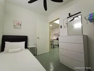 a bedroom with a white bed and a dresser at Adno Homestay Batu Kawan 5SB in Simpang Ampat