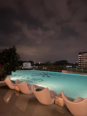 a swimming pool with chaise lounge chairs on a building at Piccadilly Green Town Luxury Stay, Ipoh in Ipoh