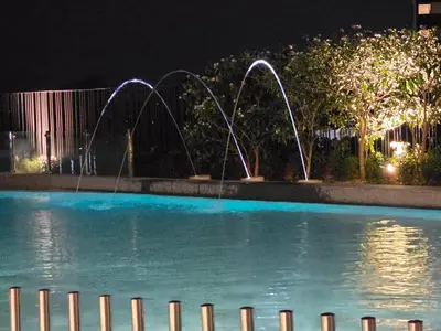 a swimming pool at night with water fountains at Piccadilly Green Town Luxury Stay, Ipoh in Ipoh