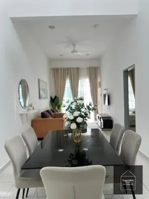 a dining room table with chairs and a vase of flowers at Ipoh Musllim Homestay Meru Tropika - 3 Bedrooms in Ipoh