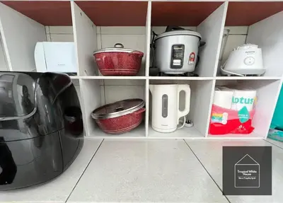 a kitchen shelf filled with pots and pans at Ipoh Musllim Homestay Meru Tropika - 3 Bedrooms in Ipoh