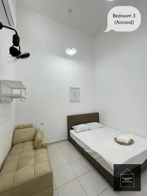 a bedroom with a bed and a couch at Ipoh Musllim Homestay Meru Tropika - 3 Bedrooms in Ipoh