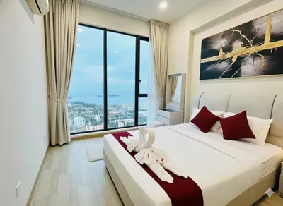 a bedroom with a bed and a large window at Peaceful Seaview Getaway Jazz Suite High Floor in Tanjong Tokong