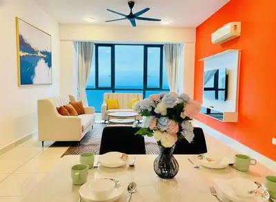 a living room with a table with a vase of flowers at Peaceful Seaview Getaway Jazz Suite High Floor in Tanjong Tokong