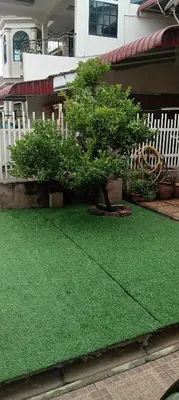 a yard of green grass with a tree on it at D Seberang Homestay in Perai