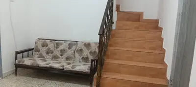 a couch sitting next to a set of stairs at D Seberang Homestay in Perai