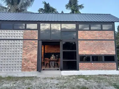 a brick house with a table in the doorway at Tepian Sawah Semanggol in Simpang Ampat Semanggol