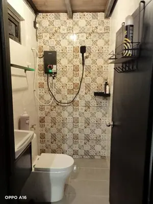 a bathroom with a toilet and a phone on the wall at Tepian Sawah Semanggol in Simpang Ampat Semanggol