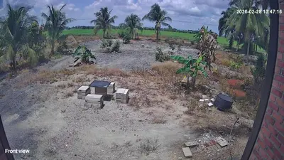 a dirt field with a house and trees in it at Tepian Sawah Semanggol in Simpang Ampat Semanggol