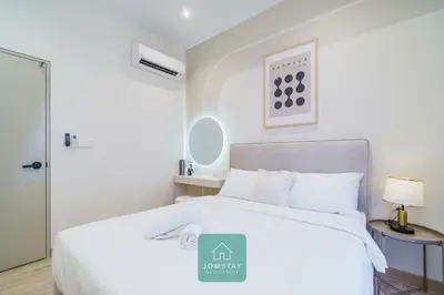 a white bedroom with a large bed with white pillows at JOMSTAY - Piccadilly Greentown Ipoh in Ipoh