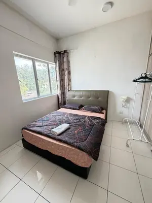 a bedroom with a bed with a remote control on it at AYAAN Freesia Snooker House at Quintet Private Parking in Tanah Rata