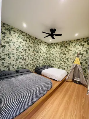 a bedroom with two beds and a ceiling fan at Homestay Cozy Dino Cameron Highlands in Tanah Rata