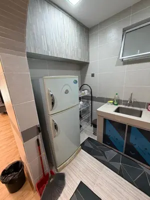 a small kitchen with a refrigerator and a sink at AYAAN MILLENIUM Family Homestay with Netflix and PS3 xprience Most Wanted 2012 and many more racing games in Tanah Rata