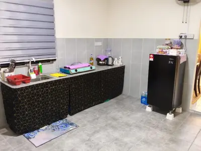 a kitchen with a counter with a sink and a refrigerator at FF Home - Homestay Teluk Intan in Teluk Intan