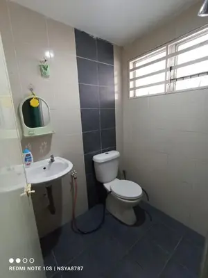 a bathroom with a toilet and a sink at De Ariffa Homestay مسلم in Lahat