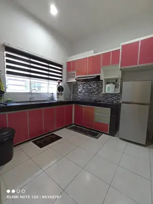 a kitchen with red cabinets and a white tile floor at De Ariffa Homestay مسلم in Lahat