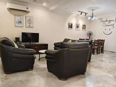 a living room with couches and a flat screen tv at Warmy 4 Bedrooms Double Storey Homestay, Few mins to Town, by MR HOMESTAY in Teluk Intan