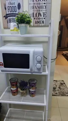 a white microwave on a shelf with some plants at Zamdynas HomestayMuslim Cameron Highland in Tanah Rata