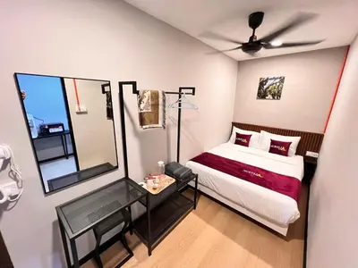 a bedroom with a bed and a table with a mirror at Aurelia Stay in Brinchang