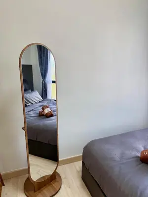 a mirror in a bedroom next to a bed at Piccadilly Ipoh by Iconique in Ipoh