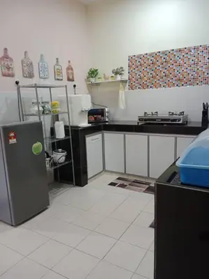 a kitchen with a counter and a refrigerator at Empatnurul Homestay Ipoh in Ipoh