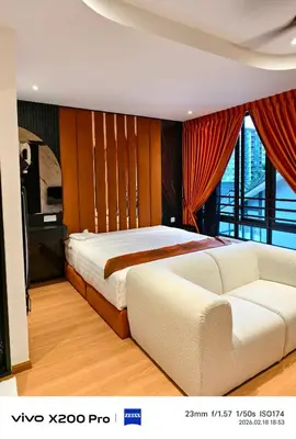 a bedroom with a large bed and a couch at Adik Aisyah Hotel Studio Room Sun Harvest Citrus Centrum Brinchang in Brinchang
