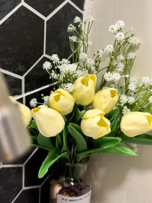 a vase filled with yellow tulips and white flowers at Swit60 Homestay in Sungai Besar