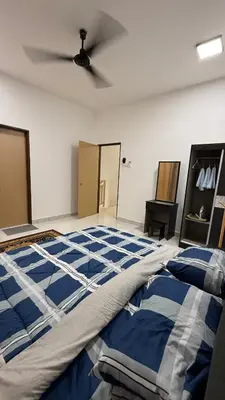 a bedroom with a bed and a ceiling fan at Homestay Azizi in Seri Iskandar