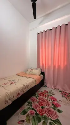 a bedroom with two beds and a window with pink curtains at Homestay Azizi in Seri Iskandar