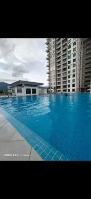 a large blue swimming pool with buildings in the background at Idham homestay 2 in Ipoh