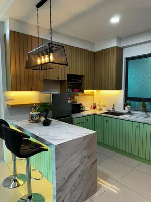 a large kitchen with green cabinets and a large island at Idham homestay 2 in Ipoh