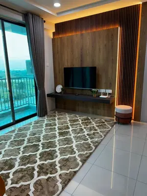 a living room with a flat screen tv and a carpet at Idham homestay 2 in Ipoh