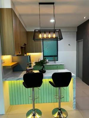 a kitchen with two black bar stools in a kitchen at Idham homestay 2 in Ipoh