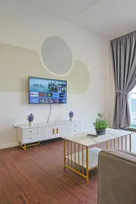 a living room with a table and a tv on the wall at Top 2 Palas Horizon Brinchang Cameron Highlands in Brinchang