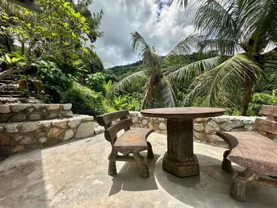 a wooden table and two chairs and a table and bench at Bao Sheng Durian Farm in Balik Pulau