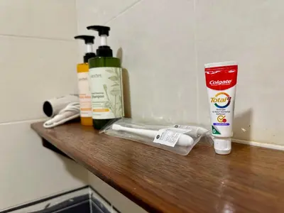 a bathroom counter with two bottles ofodorizers and a cup at Bao Sheng Durian Farm in Balik Pulau