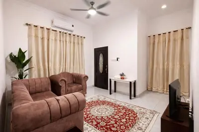 a living room with a couch and a chair and a tv at Homestay Tikam Batu -Nearside to Jendela Foodcourt in Sungai Petani