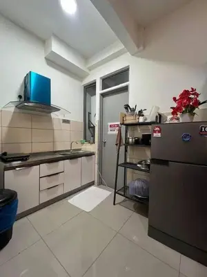 a kitchen with a counter top and a refrigerator at Norlinda palas homestay in Brinchang