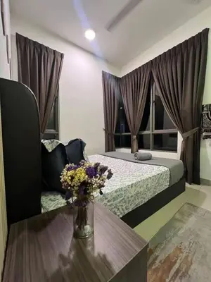 a bedroom with a bed and a table with a vase of flowers at Norlinda palas homestay in Brinchang