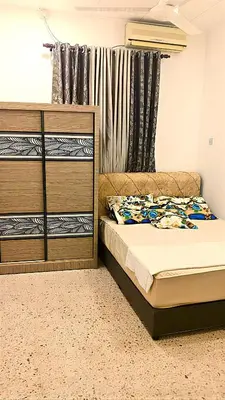 a bedroom with a bed and a dresser at A K Homestay in Sungai Petani