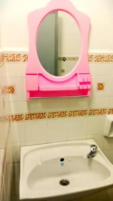 a pink mirror above a sink in a bathroom at A K Homestay in Sungai Petani