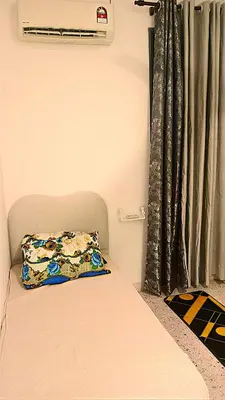 a bed with a pillow on it next to a window at A K Homestay in Sungai Petani
