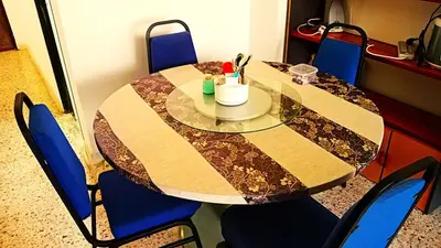 a dining room table with blue chairs around it at A K Homestay in Sungai Petani